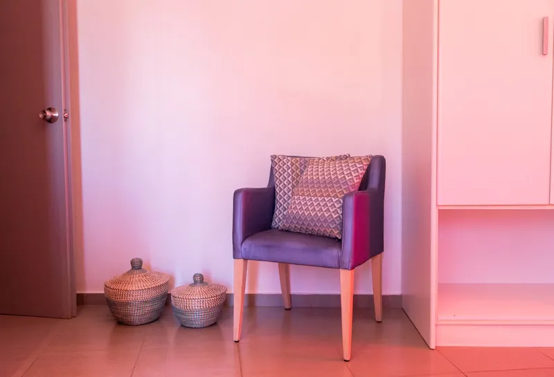 Una poltrona viola in un angolo rosa