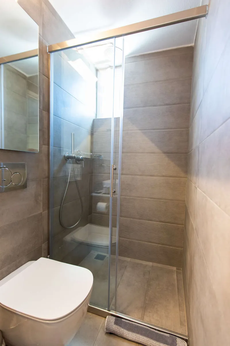 Un bagno con doccia e piastrelle grigie